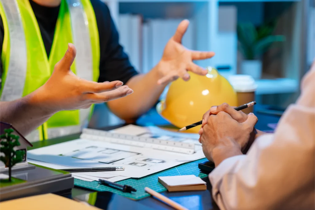 Architectural Team Discussing Blueprints in Brightly Lit Office