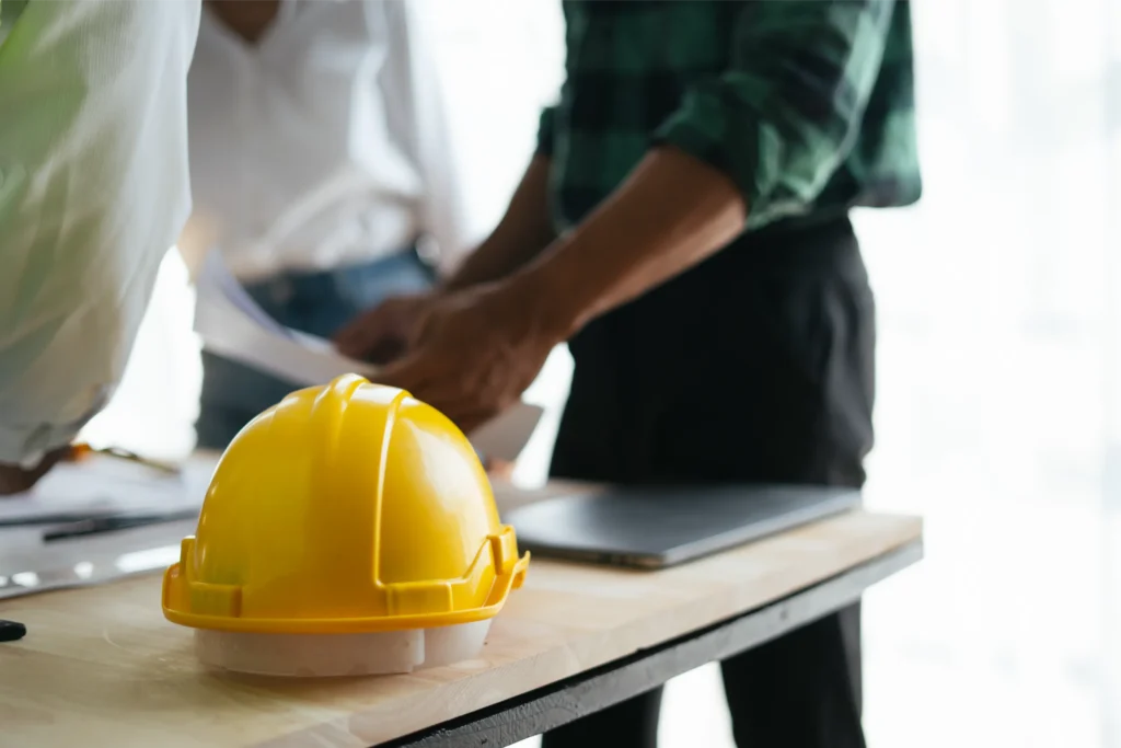 Construction Meeting with a Yellow Hardhat on Table